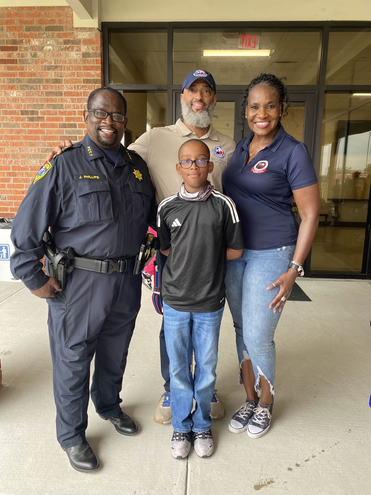 Tahir Charles at a community event with local families and a constable
