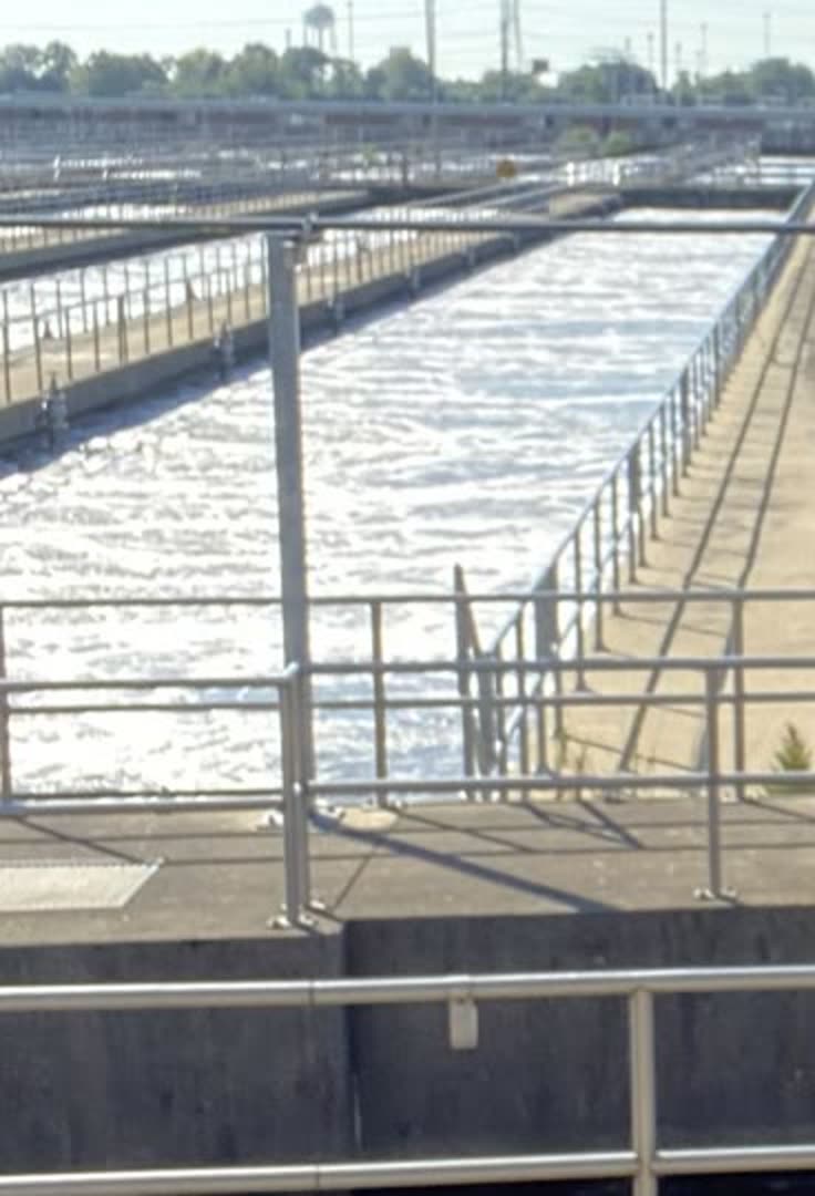 Aeration channels at a wastewater treatment plant, water churning between concrete basins
